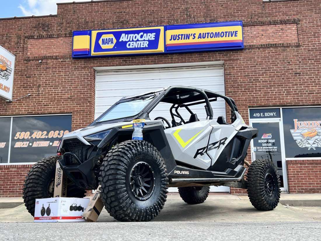 NAPA AutoCare storefront of Justin's Automotive at 419 E Broadway in Enid, with a Polaris RZR side-by-side parked out front